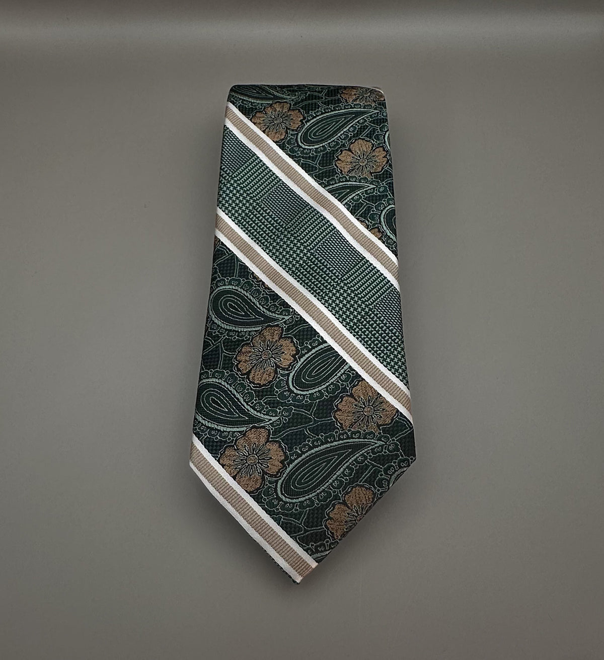 A patterned necktie with diagonal stripes and paisley motifs in dark green, beige, and brown.
