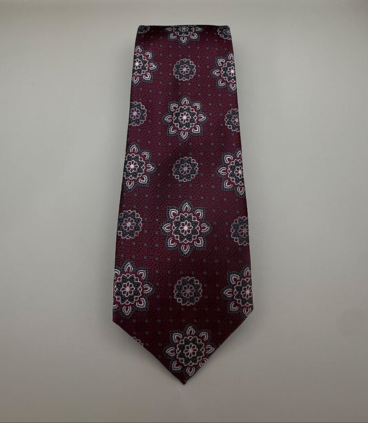 A classic necktie with a deep burgundy base and a detailed geometric medallion pattern in light gray, dark gray, and burgundy.